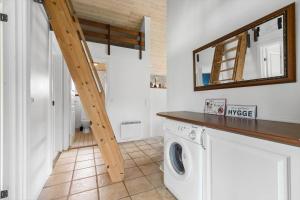 a washing machine in a laundry room with a mirror at 8843-Glesborg-Lyngtoften-34 in Glesborg