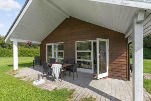 a patio with a table and chairs on a house at 8843-Glesborg-Lyngtoften-34 in Glesborg