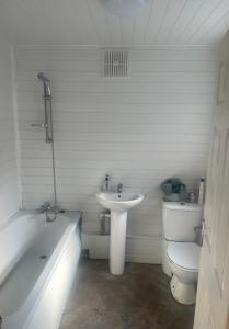 a bathroom with a tub and a sink and a toilet at Wolverhampton Room in Wolverhampton