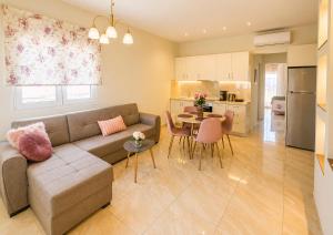 a living room and kitchen with a couch and a table at Ma Maison Rose in Kremasti