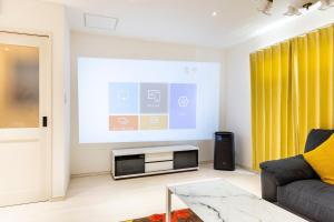 a living room with a couch and a projection screen at nonon in Osaka