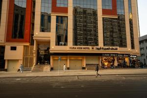 people walking down the street in front of a building at Alhijra View 2 - فندق الهجرة فيو 2 in Mecca +66 photos