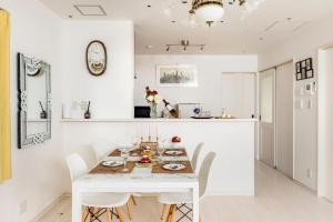 a white dining room with a white table and chairs at nonon in Osaka