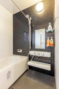 a bathroom with a tub and a sink and a mirror at nonon in Osaka +44 photos