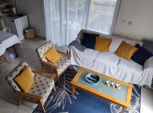 a living room with a couch and chairs and a table at Ti kaz Annah in Le Tampon