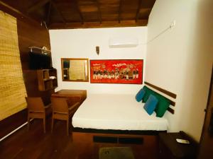 a small bedroom with a bed and a table at Luck Uyana Cabana Pinnawala in Pinnawala