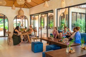 a group of people sitting at tables in a restaurant at Arcana Wellness Center - Adults Only in Ko Phangan