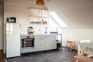 a kitchen with white cabinets and a white refrigerator at Apartmán 7J in Hnanice