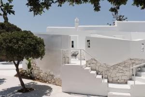 a white house with stairs and a tree at Anome Experience Hotel in Ornos