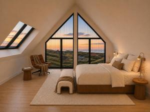 a bedroom with a large bed with a large window at De Duyn in Midsland