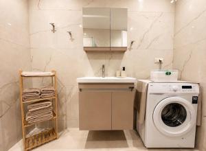 a bathroom with a washing machine and a sink at ΕΝ ΑΛΩ Residences in Kiveri