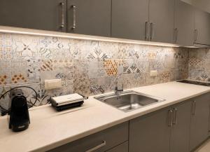 a kitchen with a sink and a tile wall at ΕΝ ΑΛΩ Residences in Kiveri +19 photos