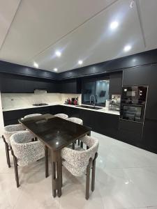 a kitchen with a wooden table and some chairs at Villa blanca in Al Maqārisah
