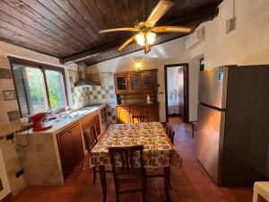 a kitchen with a table and a ceiling fan at Tenuta Ciaramiti Luxury Garden & Pool in Brattirò