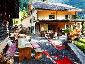 a patio with tables and chairs in front of a house at Berggasthaus Obbort in Linthal