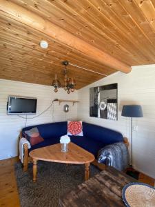 a living room with a blue couch and a table at Snøhetta Camping in Hjerkinn