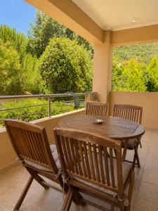 a porch with a wooden table and chairs on a balcony at Studios Galini Porto Koufo in Porto Koufo +37 photos