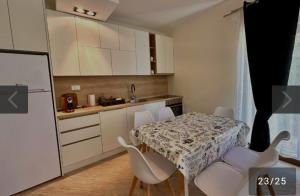 a small kitchen with a table and chairs and a refrigerator at Salatić-Lekić apartmani in Čanj