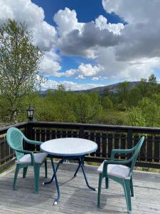 a table and two chairs sitting on a deck at Snøhetta Camping in Hjerkinn +55 photos