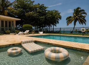 a swimming pool with two chaise lounges and two chairs at Villa Marelena Beachfront Villa Aguada Near Rincón in Tablonal