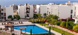 an apartment with a swimming pool in front of a building at Idyll Homes THE PENTHOUSE in Avdhelleron