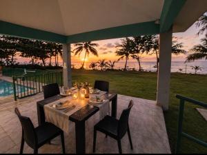 a dining table and chairs with a view of the ocean at Villa Marelena Beachfront Villa Aguada Near Rincón in Tablonal