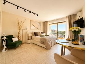 a bedroom with a bed and a table and a couch at La Marina Cannes Suites in Mandelieu-La Napoule