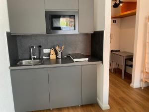 a kitchen with a sink and a microwave at Apartment Altstadt Stralsund in Stralsund +6 photos
