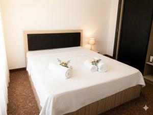 a bedroom with a bed with two towels on it at Villa Italia Boutique in Mamaia Sat/Năvodari