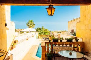 an outdoor patio with tables and a pool at Narcisa Farmhouse B&B in Nadur