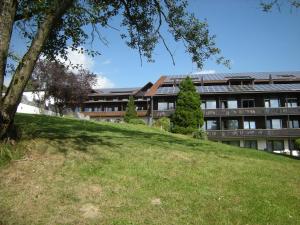an apartment building with a grassy hill in front of it at Obergeschoss Bungalow 47 in der Ferienanlage RHÖN RESIDENCE in Dipperz