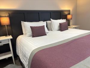 a bedroom with a large bed with two lamps at The Courtyard Apartment, Brampton Town Centre, Hadrians Wall - Sleeps 2 in Brampton
