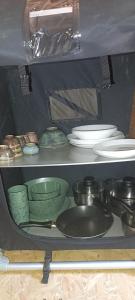 a shelf filled with plates and bowls and dishes at Maringotka pod hvozdem in Spešov