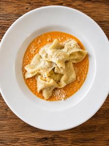 a bowl of food on a white plate on a table at Locanda Vecchio Mulino in Sarnico +20 photos