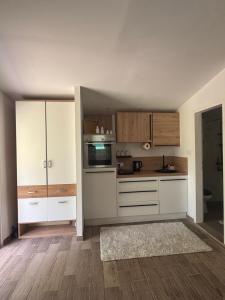 a kitchen with white cabinets and wooden floors at Danguba 5 in Nova Pazova