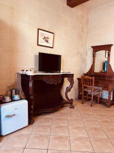 a desk with a computer on it in a room at Narcisa Farmhouse B&B in Nadur