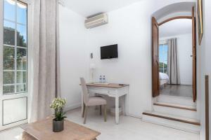 a white room with a desk and a mirror at Hôtel Beau Site - Cap d'Antibes in Antibes