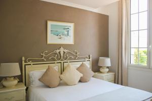 a bedroom with a bed with white sheets and pillows at Hôtel Beau Site - Cap d'Antibes in Antibes +65 photos
