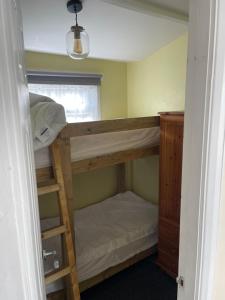 a room with two bunk beds and a window at Sheppey Village Roxy in Leysdown-on-Sea