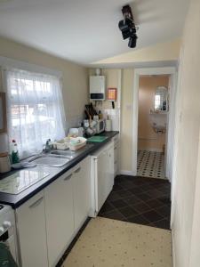 a kitchen with white cabinets and a sink at Sheppey Village Roxy in Leysdown-on-Sea
