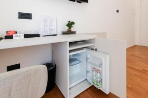 a white desk with an open refrigerator in a room at Lumen Boutique Stay in Naples