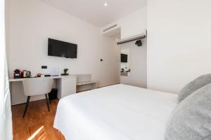 a bedroom with a white bed and a desk at Lumen Boutique Stay in Naples