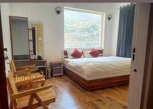a bedroom with a bed and a large window at Virasat in Uttarkāshi