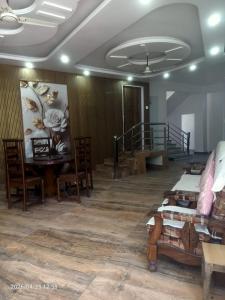 a room with a table and chairs and a painting on the wall at Virasat in Uttarkāshi