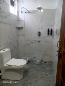 a white bathroom with a toilet and a shower at Virasat in Uttarkāshi