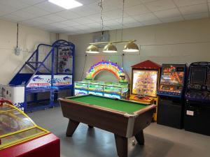 a room with a pool table and arcade games at Sheppey Village Roxy in Leysdown-on-Sea