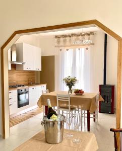 a kitchen with a table with a bottle of wine at La Lidia in Sassari