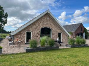 a brick house with a patio and a table at B&B De Cootjes in Ossendrecht