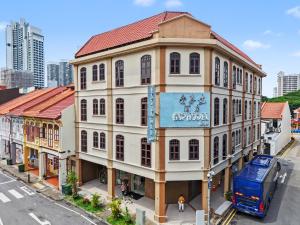 a large building with a sign on it on a street at Asphodel Inn - Newly Renovated in Singapore