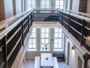 a staircase with a table in a room with windows at STF Visby Hamn Vandrarhem in Visby